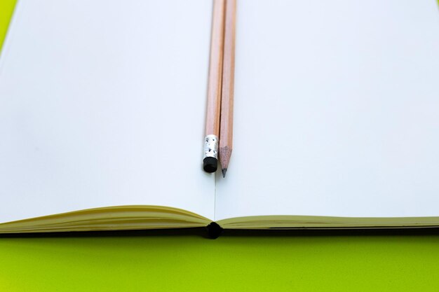 Pencils on notebooks or paper on green background