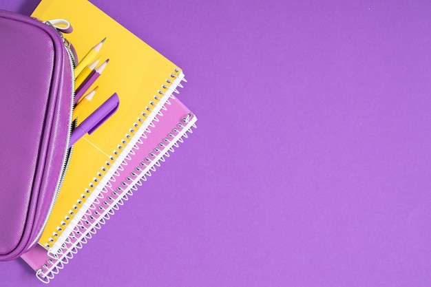 紫色の背景に鉛筆とノートブック学校に戻るフラットレイトップビューコピースペース