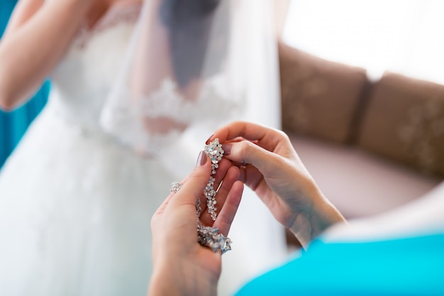 Pendent jewelry made of silver and a diamond oval-shaped women earrings for the bride. Closeup.