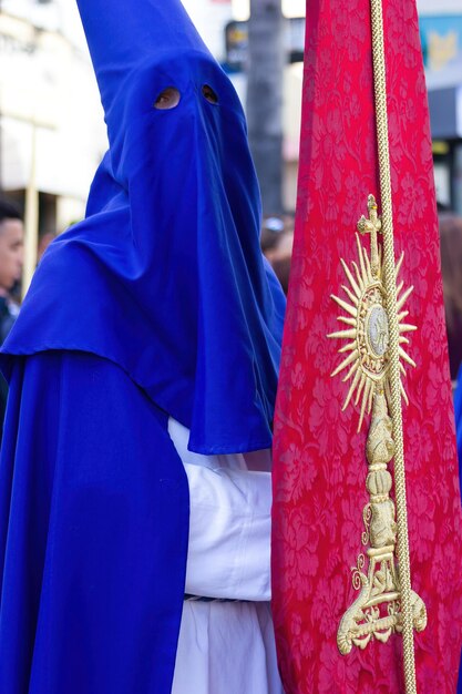 Penitent or Nazarene with a banner during the Holy Week procession