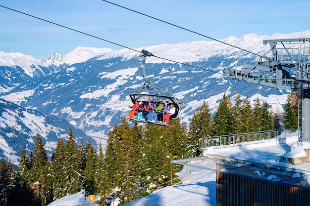 Photo penken, austria - february 6, 2019: people skiers on chair lift in penken park ski resort in tyrol in mayrhofen in zillertal valley, austria in winter alps. cable cars in alpine mountains