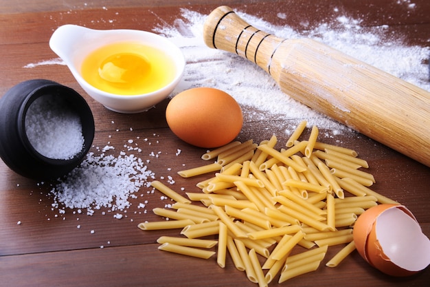 Penne-deegwaren bolognese, spaghetti klaar voor het koken op de achtergrond van ei