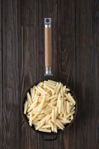 Penne Italian pasta in a frying pan, rustic style.
