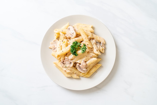 Penne pasta carbonara roomsaus met champignons - italiaanse keukenstijl