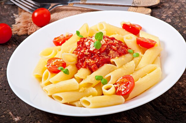 Penne pasta met bolognesesaus, parmezaanse kaas en basilicum