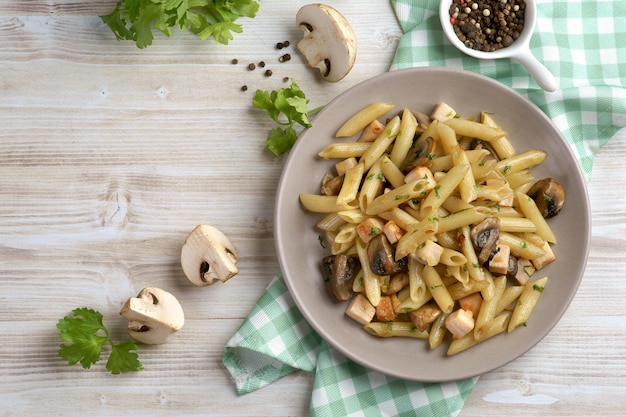 Penne pasta met champignons en kip op grijs