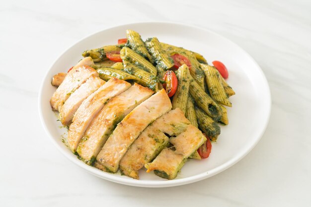 Photo penne pasta in pesto sauce with grilled chicken