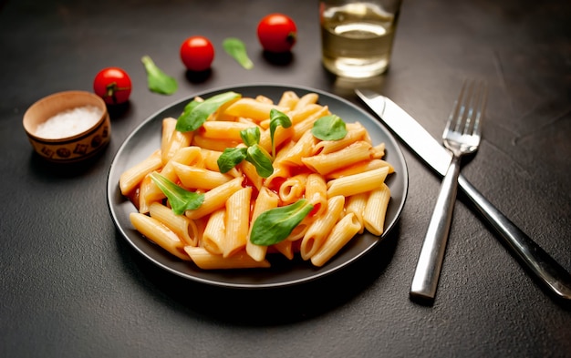 Penne pasta in a plate on a concrete background