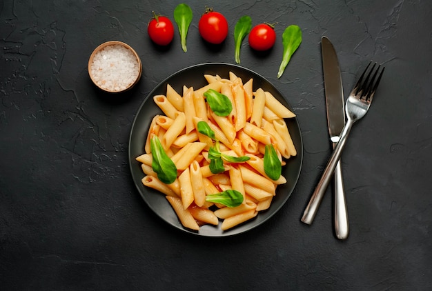 Penne pasta in a plate on a concrete background