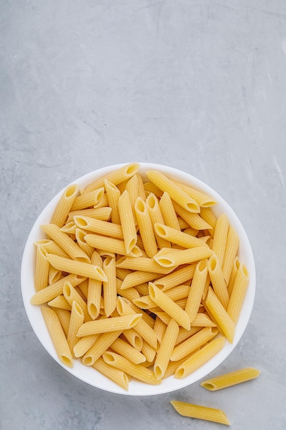 Penne pasta Rauwe Italiaanse penne pasta op grijze stenen achtergrond