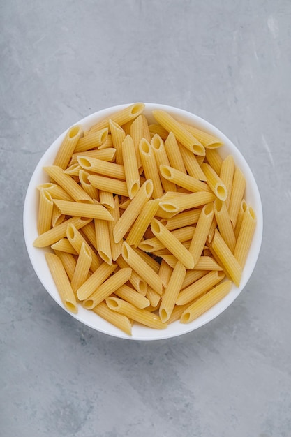 ペネパスタ 灰色の石の背景に生地のイタリアのペンネパスタ