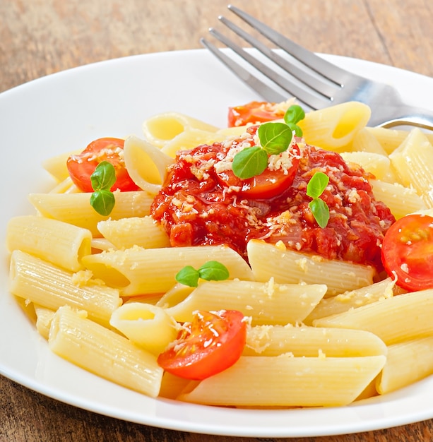 Penne pasta with bolognese sauce, parmesan cheese and basil