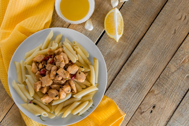 Penne pasta with chicken and vegetables in tomato sauce