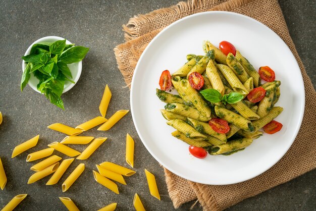 penne pasta with pesto sauce and tomatoes - vegan and vegetarian food style