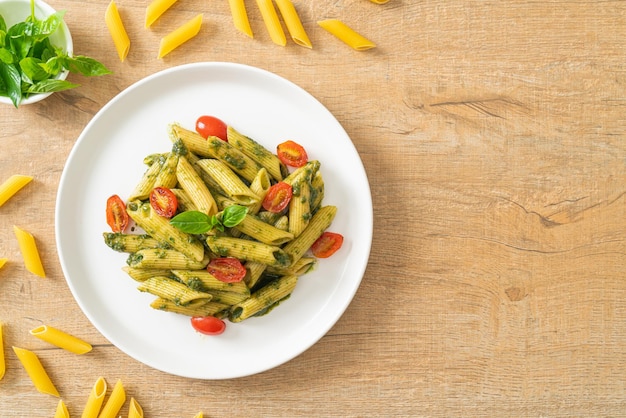 Foto pasta penne con salsa di pesto e pomodori