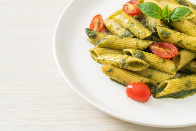 Photo penne pasta with pesto sauce and tomatoes