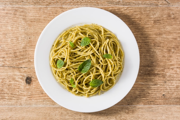 Penne pasta with pesto sauce on wooden table