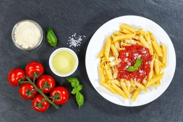 Penne Rigatoni Rigate pasta top view meal from Italy lunch with tomato sauce slate on a plate