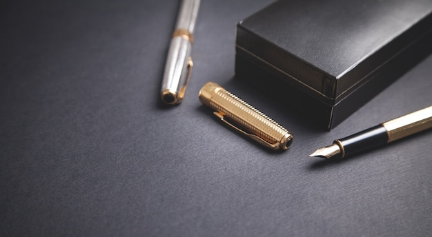 Pens and box on the black background.