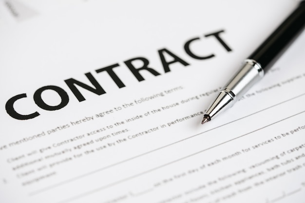 Pens and contract documents are placed on the desk.