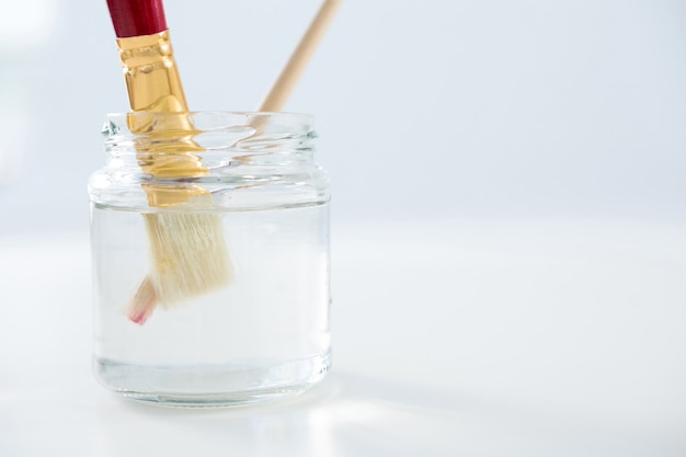 Penselen ondergedompeld in water op een witte ondergrond