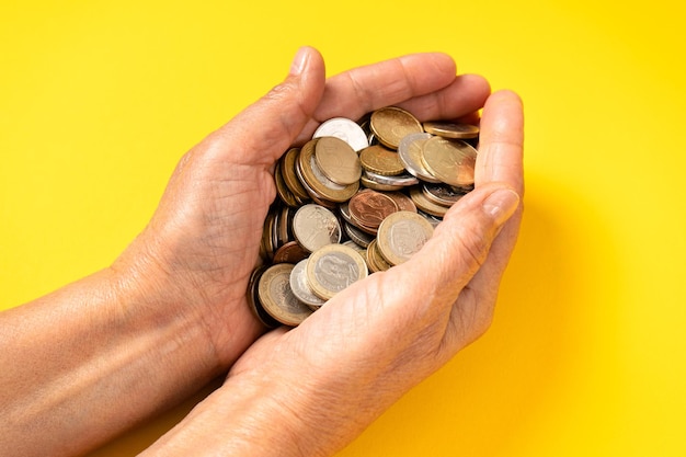 Pensioen, spaargeld van de oude vrouw. Veel munten in de handen van een oudere vrouw. Detailopname