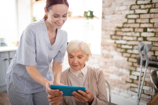 Pensioner feeling excited while watching video on tablet