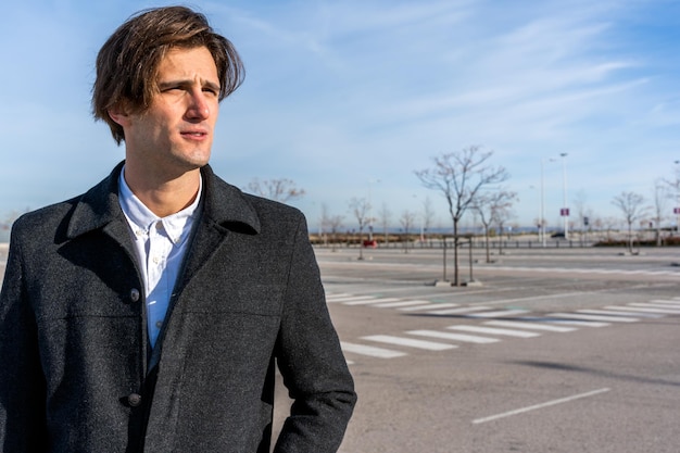 Pensive adult businessman looking away on street