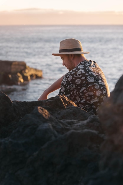 Pensive boy sitting in front of the sea