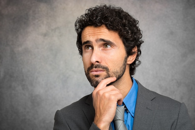 Pensive businessman against a grungy background