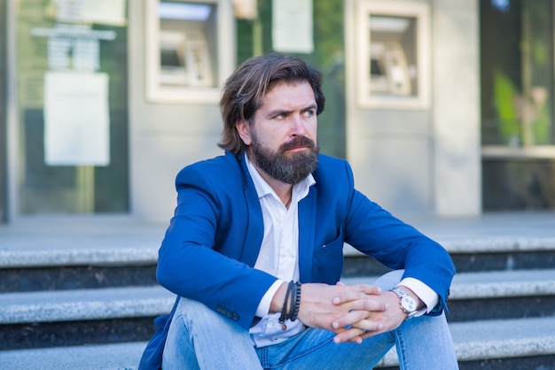 Pensive businessman in formalwear sitting on stairs. Man Relaxing Outside.