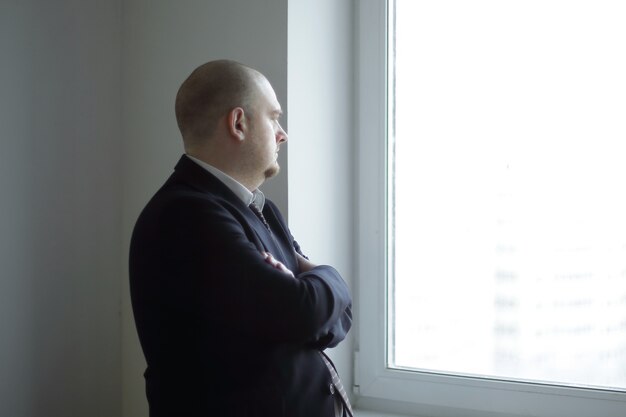 Pensive businessman looking at a blank office window