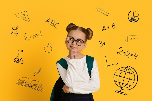 Задумчивая милая школьница, стоящая на желтом фоне с нарисованными образовательными иконами