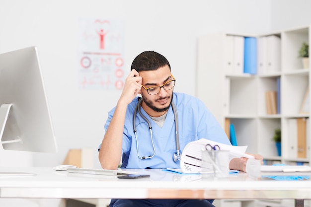 Pensive Doctor Sitting at Desk