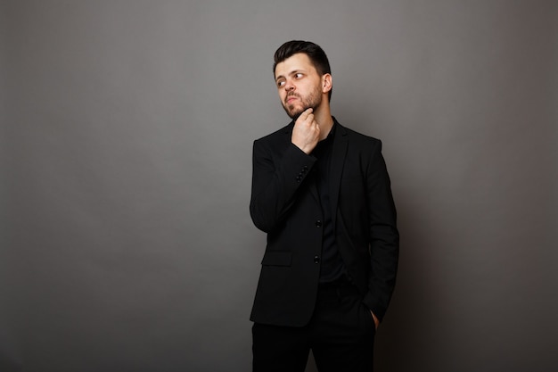 Pensive elegant man in black business suit