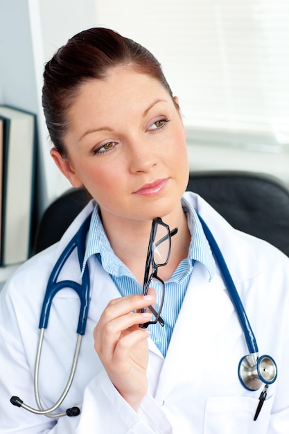 Pensive female doctor sitting in her office