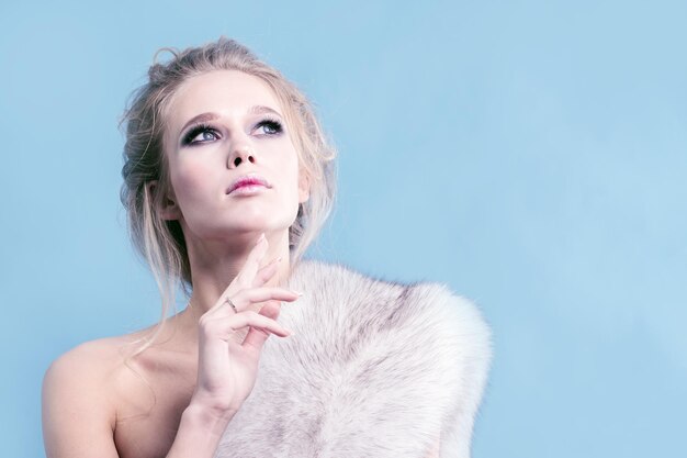 Pensive girl with fur overcast in studio close up