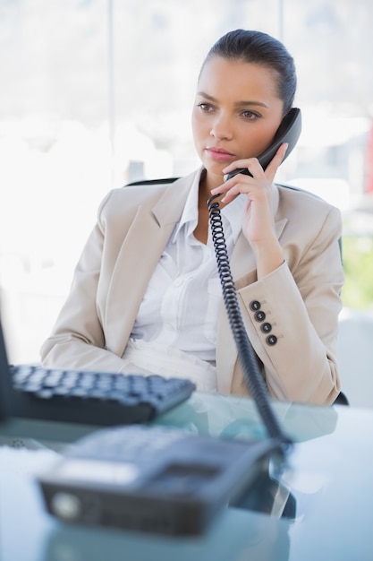 Pensive gorgeous businesswoman answering the phone