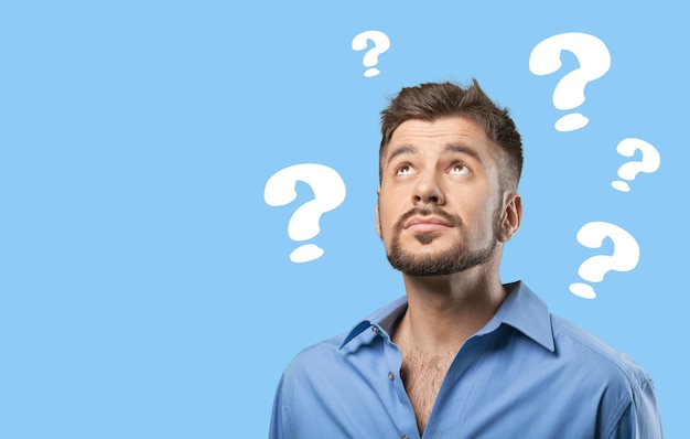 Pensive man, blue background with question marks