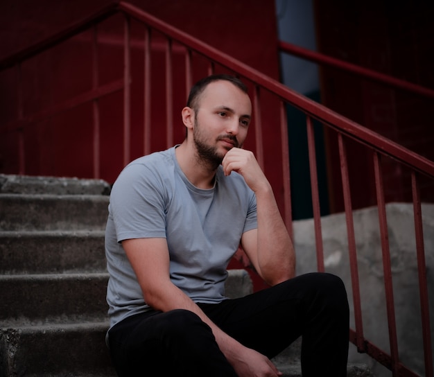 Pensive man with a beard sits on the steps