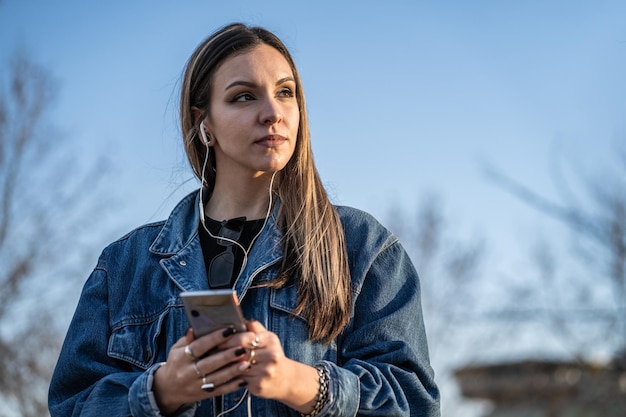 Foto giovane donna bionda graziosa pensierosa con lo smartphone a disposizione. fotografia orizzontale