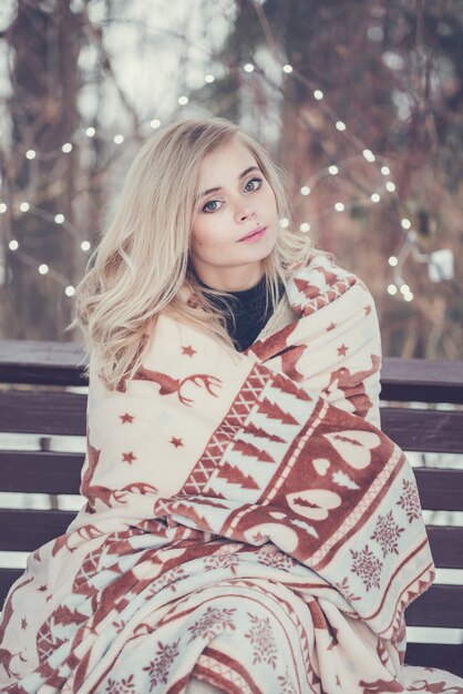 Pensive relax and happy girl sitting in the winter forest.