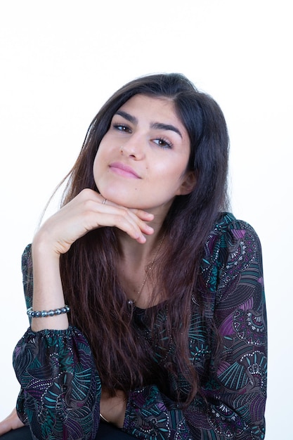 Pensive smiling brunette woman standing hand under chin natural smile in white background