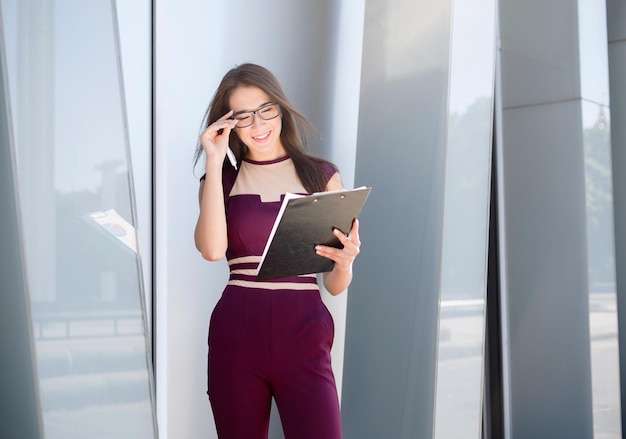 Pensive successful businesswoman with notepad outdoors, thinking about project. Inspiration, motivation and brainstorming concept, copy space