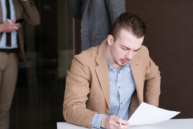 Pensive thoughtful business man at work contemplating over documents in office confident successful broker holding papers