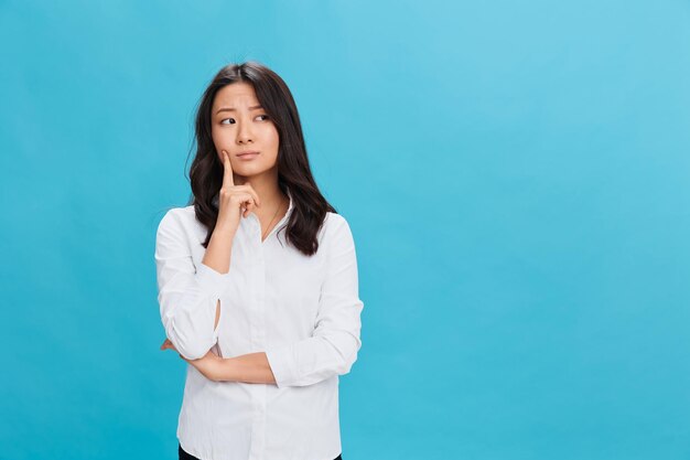 Pensive thoughtful cute asian businesswoman in classic office
dress code can39t make difficult decision posing isolated on blue
studio background cool business offer people emotions business
concept