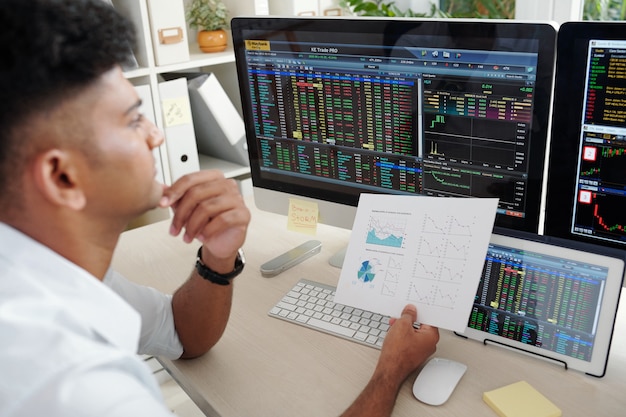 Pensive trader analyzing business activity of company before making decision on buying or selling shares