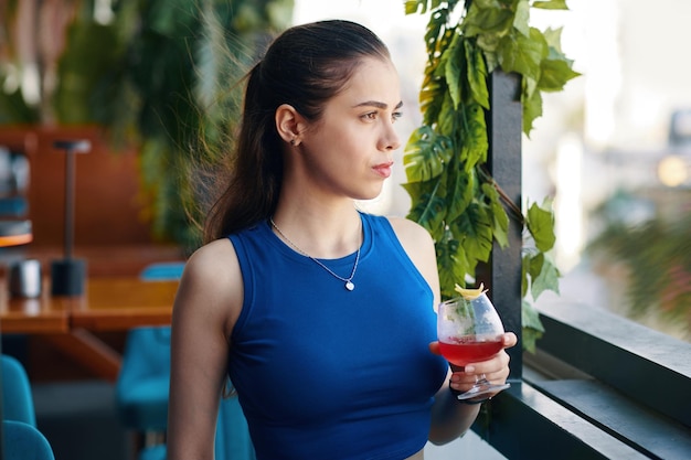 Pensive woman with glass of cocktail