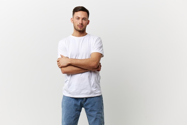 Pensive young thoughtful tanned handsome man in basic tshirt\
cross hands think about business decision posing isolated on white\
studio background copy space banner people emotions lifestyle\
concept