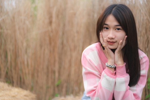 Pensive young woman sitting in the fields and thinking about future while looking away